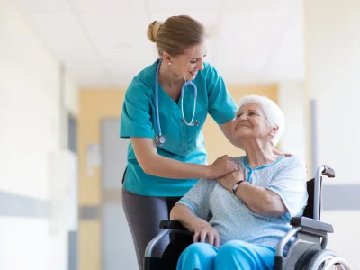 Senior woman in wheelchair with nurse in hospital